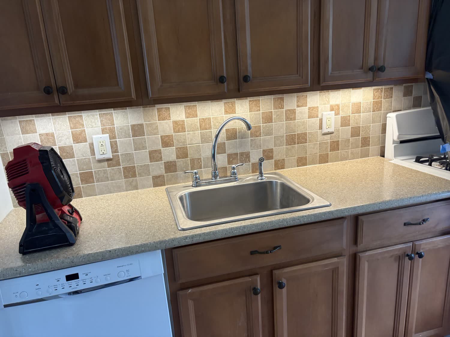 Under cabinet LED lighting over a kitchen sink and backsplash