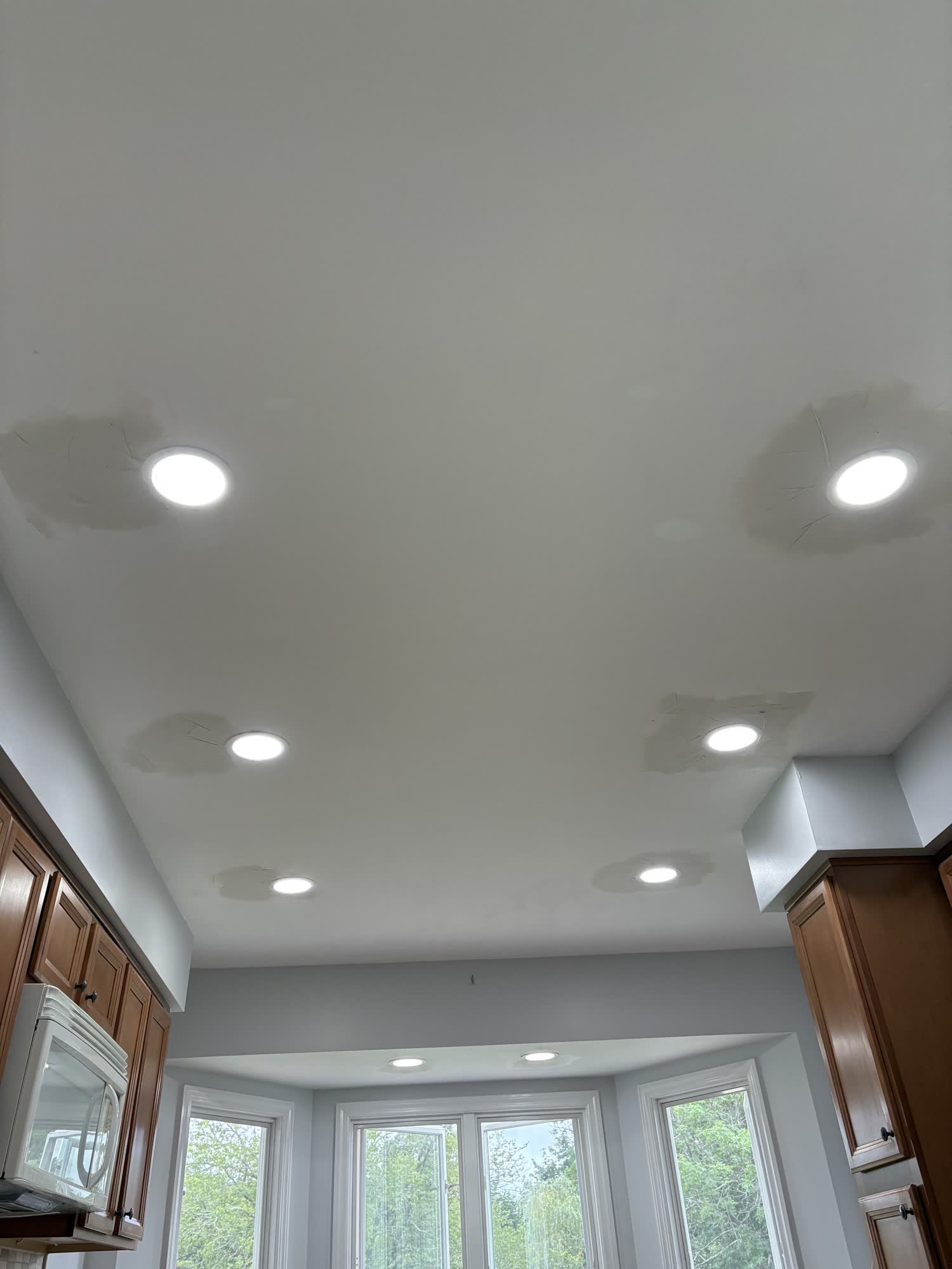 Kitchen ceiling with new recessed LED lights and drywall patches at the old can locations