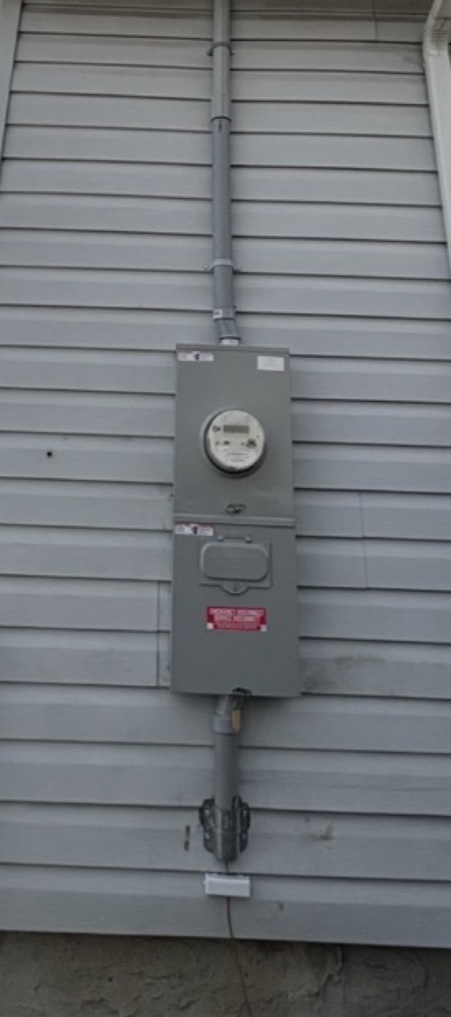 Outdoor meter and service disconnect with conduit riser on gray siding
