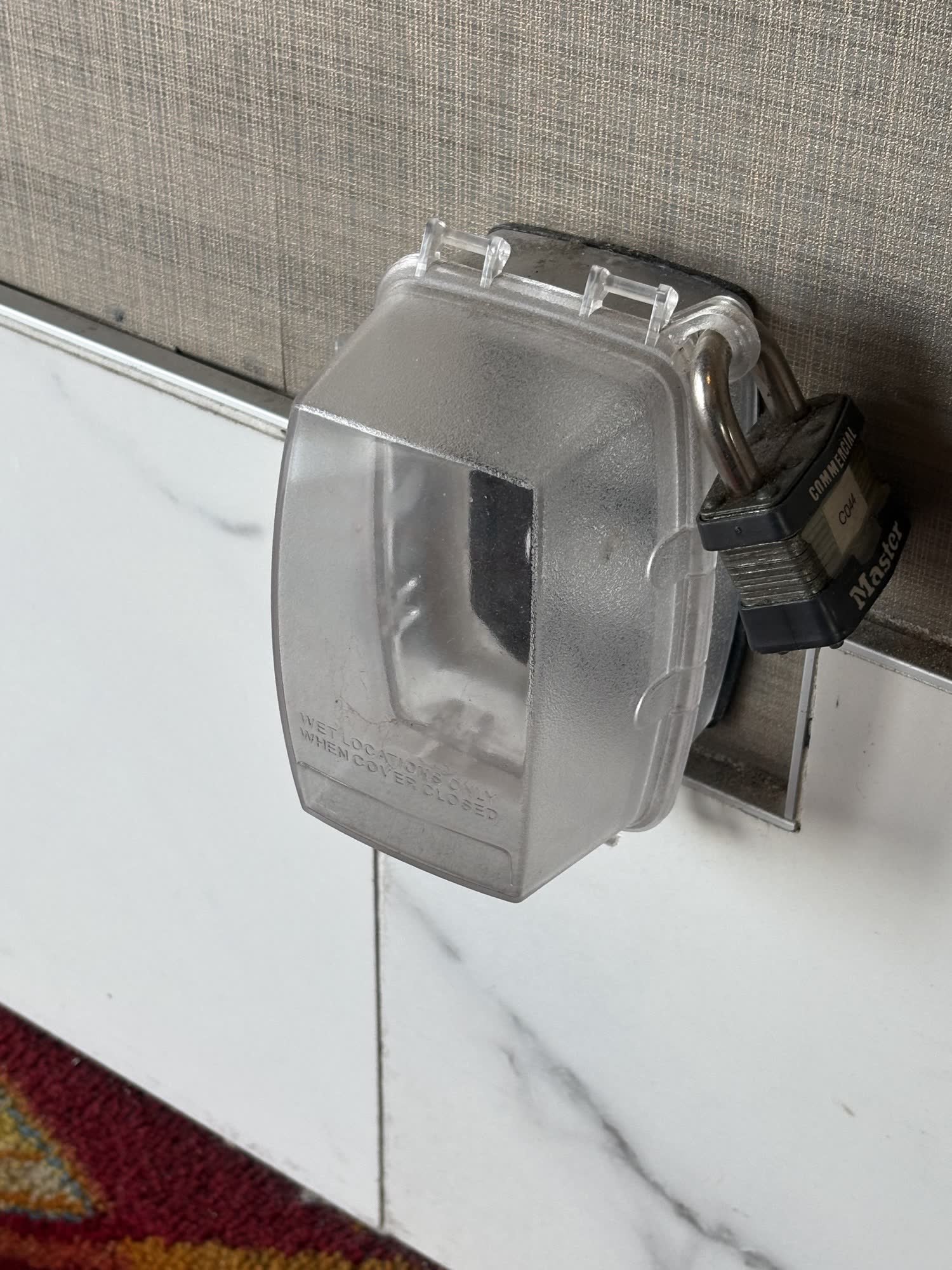 Weatherproof outdoor receptacle in a locked in-use cover